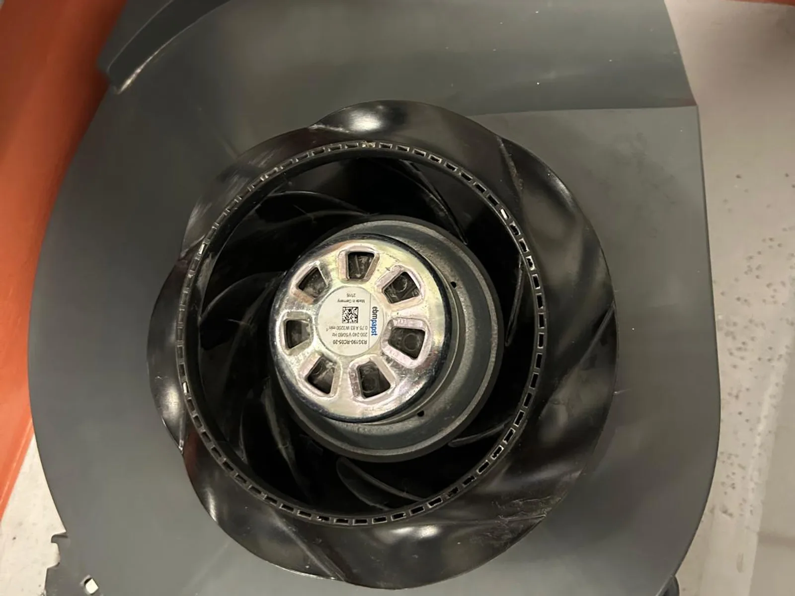 Impeller and motor of a heat-recovery unit after cleaning, blades clean and motor visible in the centre.